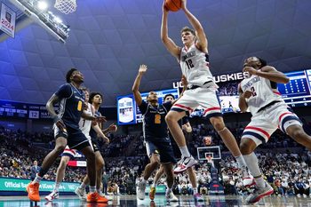 Dec 5, 2025; Storrs, Connecticut, USA; UConn Huskies center Eric Reibe (12) grabs the rebound  against the East Texas A&M Lions in the second half at Harry A. Gampel Pavilion. Mandatory Credit: David Butler II-Imagn Images
