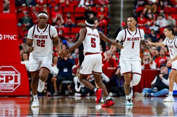Dec 6, 2025; Raleigh, North Carolina, USA; NC State Wolfpack guard Tre Holloman (5) high fives forward Ven-Allen Lubin (22) and forward Darrion Williams (1) during the second half of the game against UNC Asheville Bulldogs at Lenovo Center. Mandatory Credit: Jaylynn Nash-Imagn Images