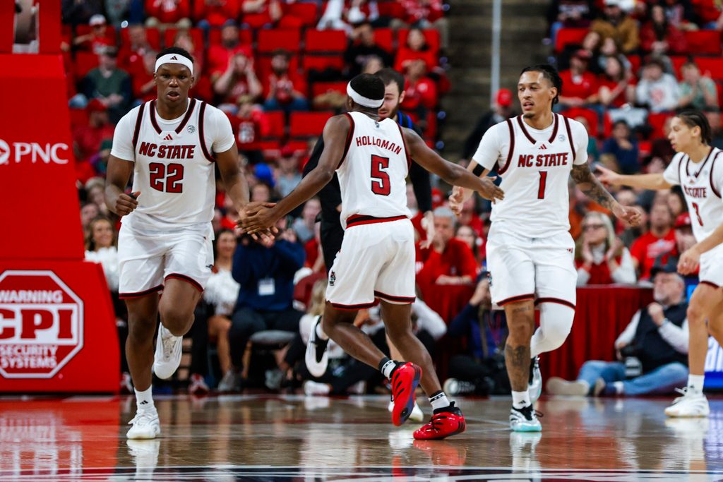 Dec 6, 2025; Raleigh, North Carolina, USA; NC State Wolfpack guard Tre Holloman (5) high fives forward Ven-Allen Lubin (22) and forward Darrion Williams (1) during the second half of the game against UNC Asheville Bulldogs at Lenovo Center. Mandatory Credit: Jaylynn Nash-Imagn Images