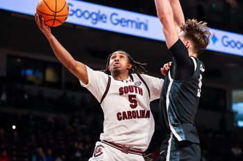 Dec 6, 2025; Columbia, South Carolina, USA; South Carolina Gamecocks guard Meechie Johnson (5) drives past Stetson Hatters forward Collin Kuhl (9) in the first half at Colonial Life Arena. Mandatory Credit: Jeff Blake-Imagn Images