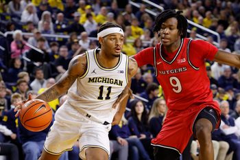 Dec 6, 2025; Ann Arbor, Michigan, USA;  Michigan Wolverines guard Roddy Gayle Jr. (11) dribbles defended by Rutgers Scarlet Knights forward Dylan Grant (9) in the first half at Crisler Center. Mandatory Credit: Rick Osentoski-Imagn Images