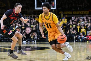 Dec 6, 2025; Iowa City, Iowa, USA; Iowa Hawkeyes guard Kael Combs (11) controls the ball as Maryland Terrapins guard Darius Adams (1) defends during the second half at Carver-Hawkeye Arena. Mandatory Credit: Jeffrey Becker-Imagn Images