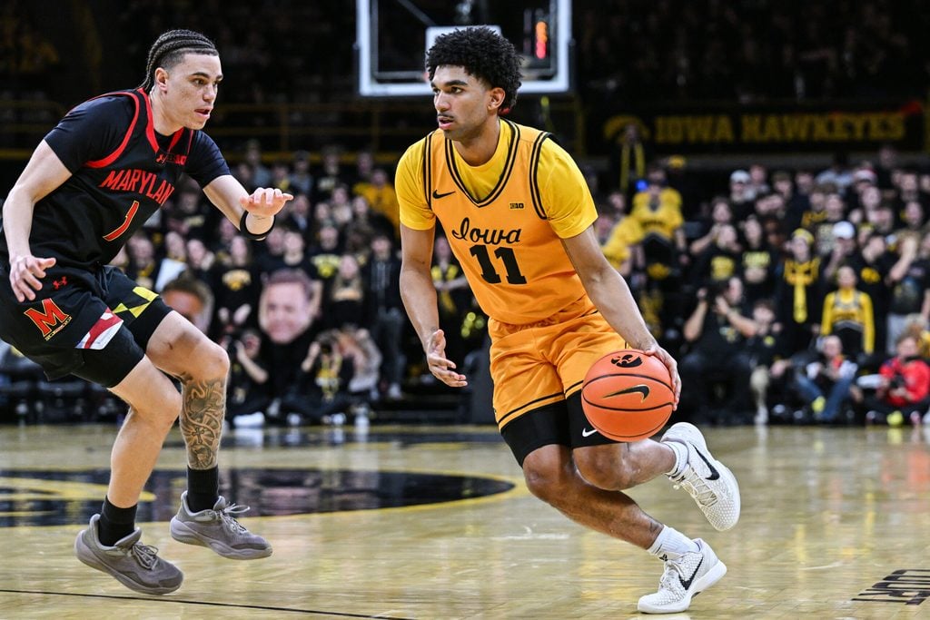 Dec 6, 2025; Iowa City, Iowa, USA; Iowa Hawkeyes guard Kael Combs (11) controls the ball as Maryland Terrapins guard Darius Adams (1) defends during the second half at Carver-Hawkeye Arena. Mandatory Credit: Jeffrey Becker-Imagn Images