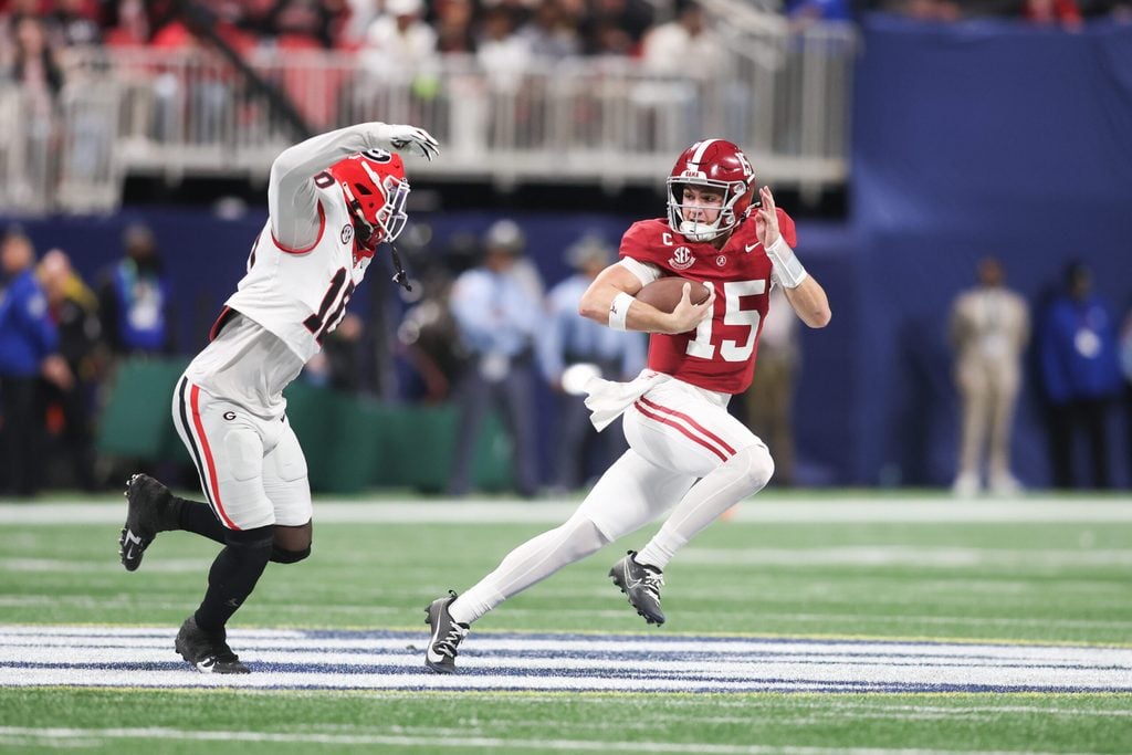 Dec 6, 2025; Atlanta, GA, USA; Alabama Crimson Tide quarterback Ty Simpson (15) rushes as Georgia Bulldogs linebacker Zayden Walker (10) defends during the fourth quarter during the 2025 SEC Championship game at Mercedes-Benz Stadium. Mandatory Credit: Brett Davis-Imagn Images