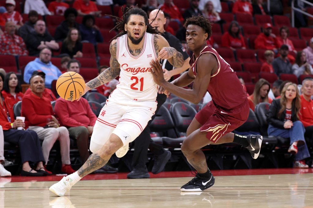 Dec 6, 2025; Houston, TX, USA; Houston Cougars guard Emanuel Sharp (21) dribbles the ball as Florida State Seminoles forward Thomas Bassong (3) defends during the first half at Toyota Center. Mandatory Credit: Troy Taormina-Imagn Images