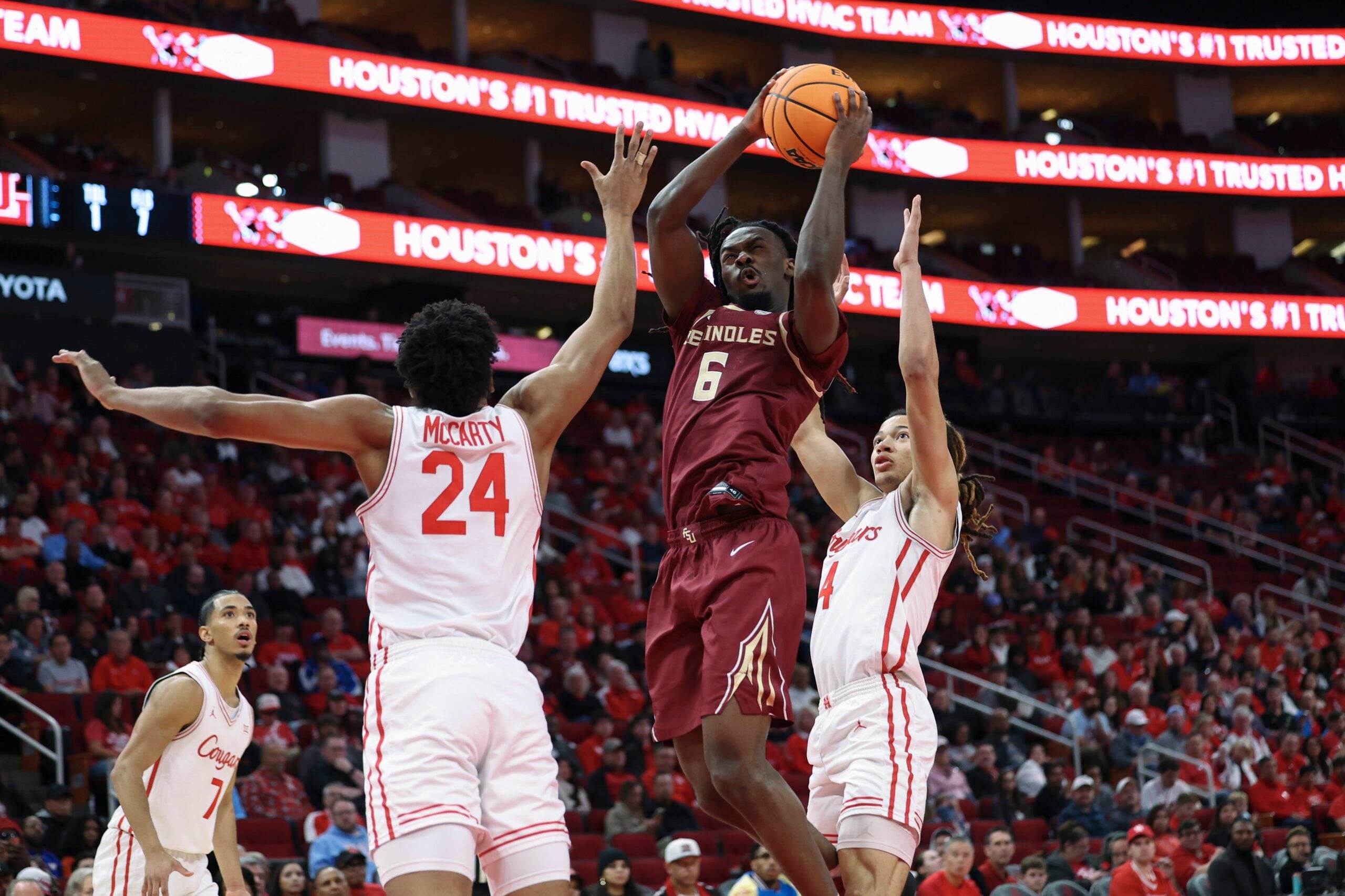 Dec 6, 2025; Houston, TX, USA; Florida State Seminoles guard Robert McCray V (6) attempts to score as Houston Cougars forward Chase McCarty (24) defends during the second half at Toyota Center. Mandatory Credit: Troy Taormina-Imagn Images