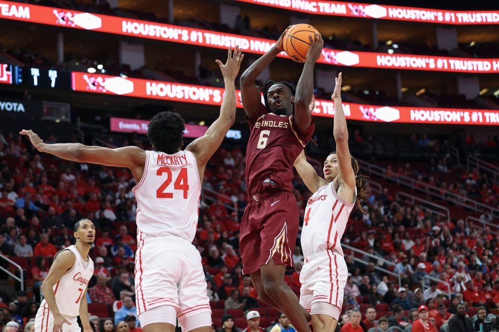 Dec 6, 2025; Houston, TX, USA; Florida State Seminoles guard Robert McCray V (6) attempts to score as Houston Cougars forward Chase McCarty (24) defends during the second half at Toyota Center. Mandatory Credit: Troy Taormina-Imagn Images