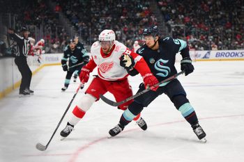 Dec 6, 2025; Seattle, Washington, USA; Detroit Red Wings center Andrew Copp (18) and Seattle Kraken defenseman Brandon Montour (62) chases the loose puck during the third period at Climate Pledge Arena. Mandatory Credit: Steven Bisig-Imagn Images