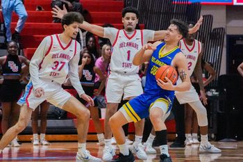 Delaware’s Christian Bliss (right) reacts after contact with Ponce James (1) and Ademar Santos in overtime in the Hornets’ 75-72 win at Delaware State’s Memorial Hall, Dec. 6, 2025.