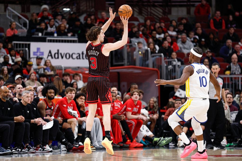 Dec 7, 2025; Chicago, Illinois, USA; Chicago Bulls guard Josh Giddey (3) shoots against Golden State Warriors forward Jimmy Butler III (10) during the second half at United Center. Mandatory Credit: Kamil Krzaczynski-Imagn Images