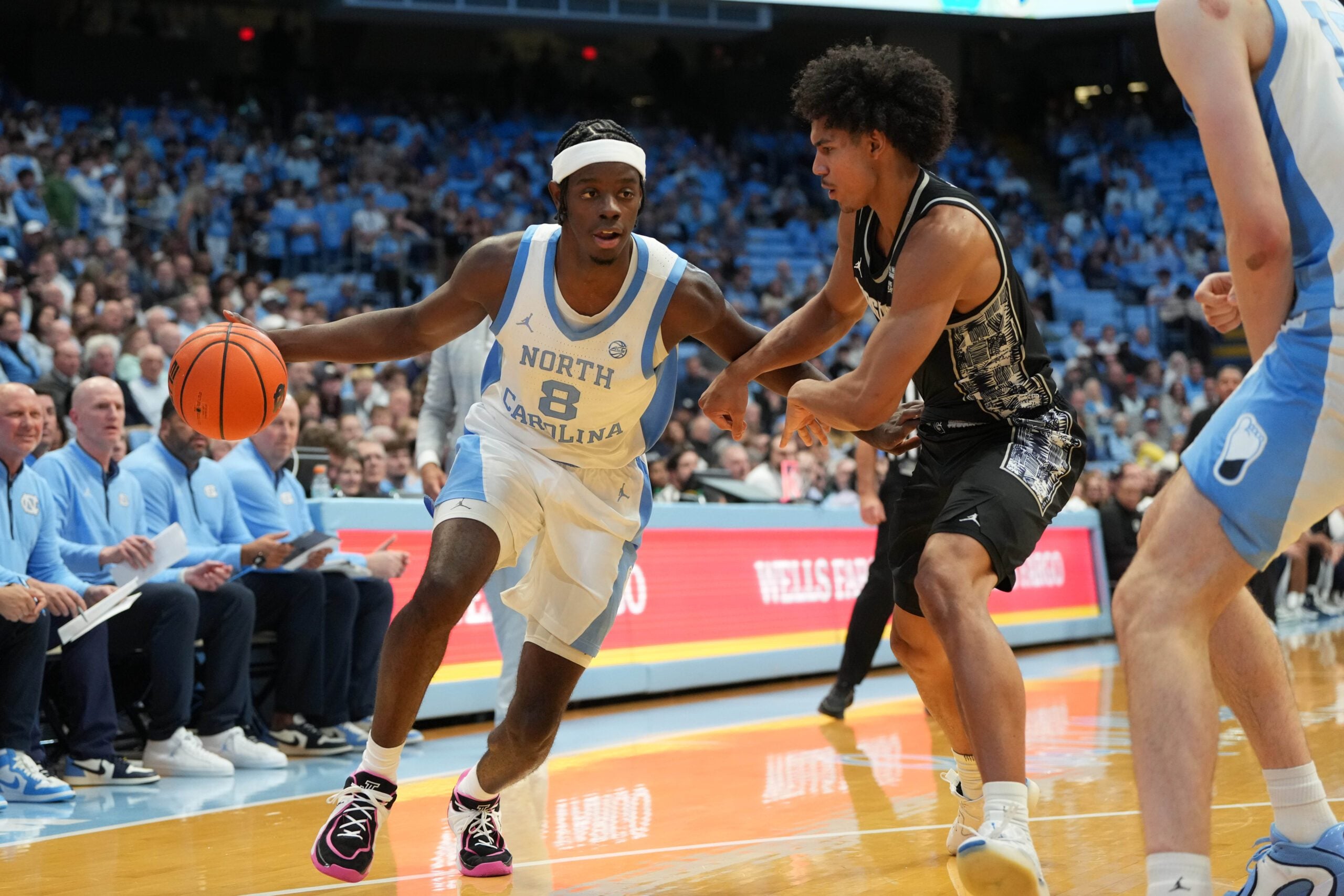 Dec 7, 2025; Chapel Hill, North Carolina, USA;  North Carolina Tar Heels forward Caleb Wilson (8) with the ball as Georgetown Hoyas forward Isaiah Abraham (7) defends in the second half at Dean E. Smith Center. Mandatory Credit: Bob Donnan-Imagn Images