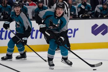 Dec 3, 2025; San Jose, California, USA; San Jose Sharks center Macklin Celebrini (71) controls the puck as defenseman Sam Dickinson (6) looks on in the second period against the Washington Capitals at SAP Center in San Jose. Mandatory Credit: David Gonzales-Imagn Images