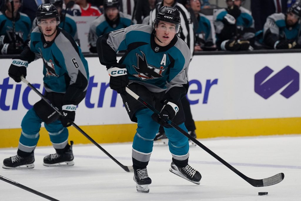 Dec 3, 2025; San Jose, California, USA; San Jose Sharks center Macklin Celebrini (71) controls the puck as defenseman Sam Dickinson (6) looks on in the second period against the Washington Capitals at SAP Center in San Jose. Mandatory Credit: David Gonzales-Imagn Images