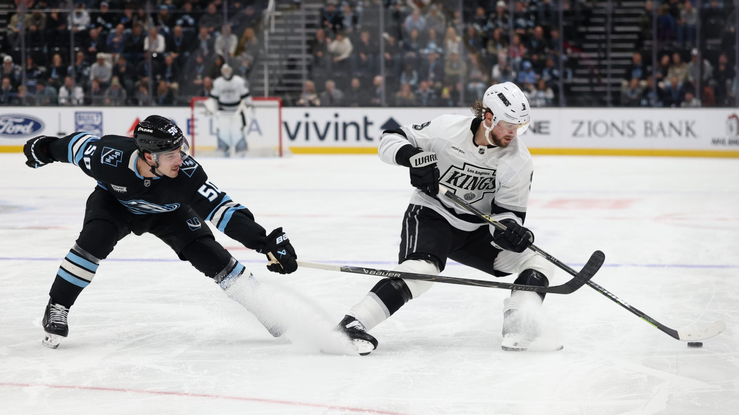 Dec 8, 2025; Salt Lake City, Utah, USA; Utah Mammoth defenseman Sean Durzi (50) and Los Angeles Kings right wing Adrian Kempe (9) play for the puck during the third period at Delta Center. Mandatory Credit: Rob Gray-Imagn Images