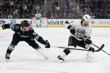 Dec 8, 2025; Salt Lake City, Utah, USA; Utah Mammoth defenseman Sean Durzi (50) and Los Angeles Kings right wing Adrian Kempe (9) play for the puck during the third period at Delta Center. Mandatory Credit: Rob Gray-Imagn Images