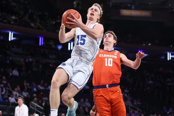 Dec 9, 2025; New York, New York, USA;  BYU Cougars guard Richie Saunders (15) drives past Clemson Tigers forward Jake Wahlin (10) in the first half at Madison Square Garden. Mandatory Credit: Wendell Cruz-Imagn Images