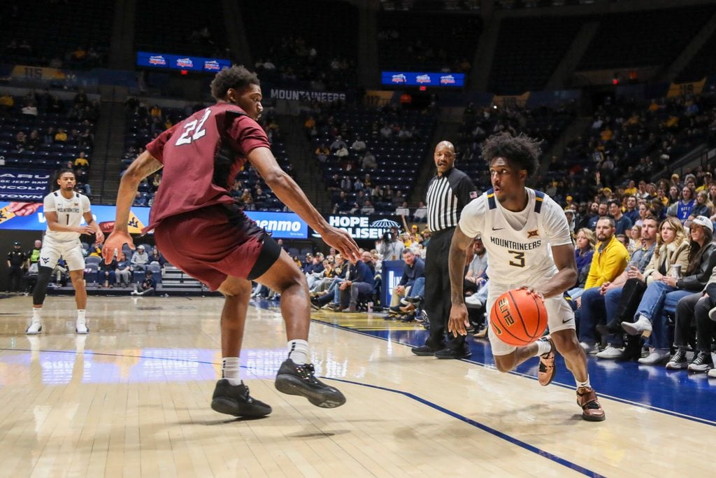 Dec 9, 2025; Morgantown, West Virginia, USA; West Virginia Mountaineers guard Honor Huff (3) drives around Little Rock Trojans forward Truman Claytor IV (22) during the second half at Hope Coliseum. Mandatory Credit: Ben Queen-Imagn Images