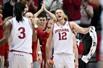 Dec 9, 2025; Bloomington, Indiana, USA; Indiana Hoosiers forward Tucker Devries (12) celebrates after guard Lamar Wilkerson (3) checks out of the game during the second half against the Penn State Nittany Lions at Simon Skjodt Assembly Hall. Mandatory Credit: Robert Goddin-Imagn Images
