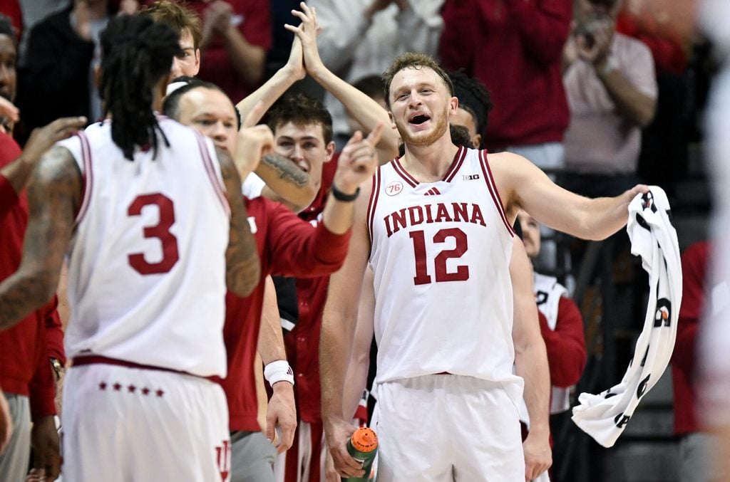 Dec 9, 2025; Bloomington, Indiana, USA; Indiana Hoosiers forward Tucker Devries (12) celebrates after guard Lamar Wilkerson (3) checks out of the game during the second half against the Penn State Nittany Lions at Simon Skjodt Assembly Hall. Mandatory Credit: Robert Goddin-Imagn Images