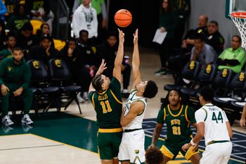 Dec 10, 2025; Waco, Texas, USA; Norfolk State Spartans forward Devon Ellis (11) scores a basket over Baylor Bears guard Isaac Williams (10) during the second half at Paul and Alejandra Foster Pavilion. Mandatory Credit: Chris Jones-Imagn Images