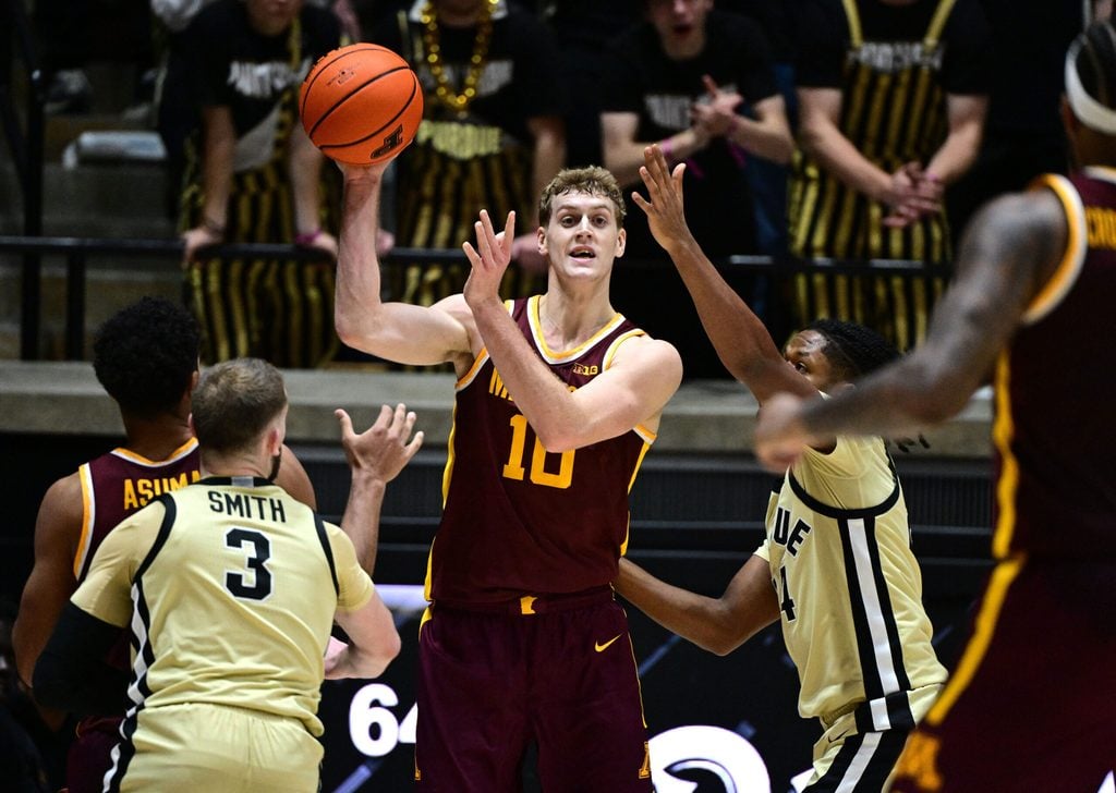 Dec 10, 2025; West Lafayette, Indiana, USA; Minnesota Golden Gophers forward Cade Tyson (10) passes the ball away from Purdue Boilermakers guard Gicarri Harris (24) during the second half at Mackey Arena. Mandatory Credit: Marc Lebryk-Imagn Images