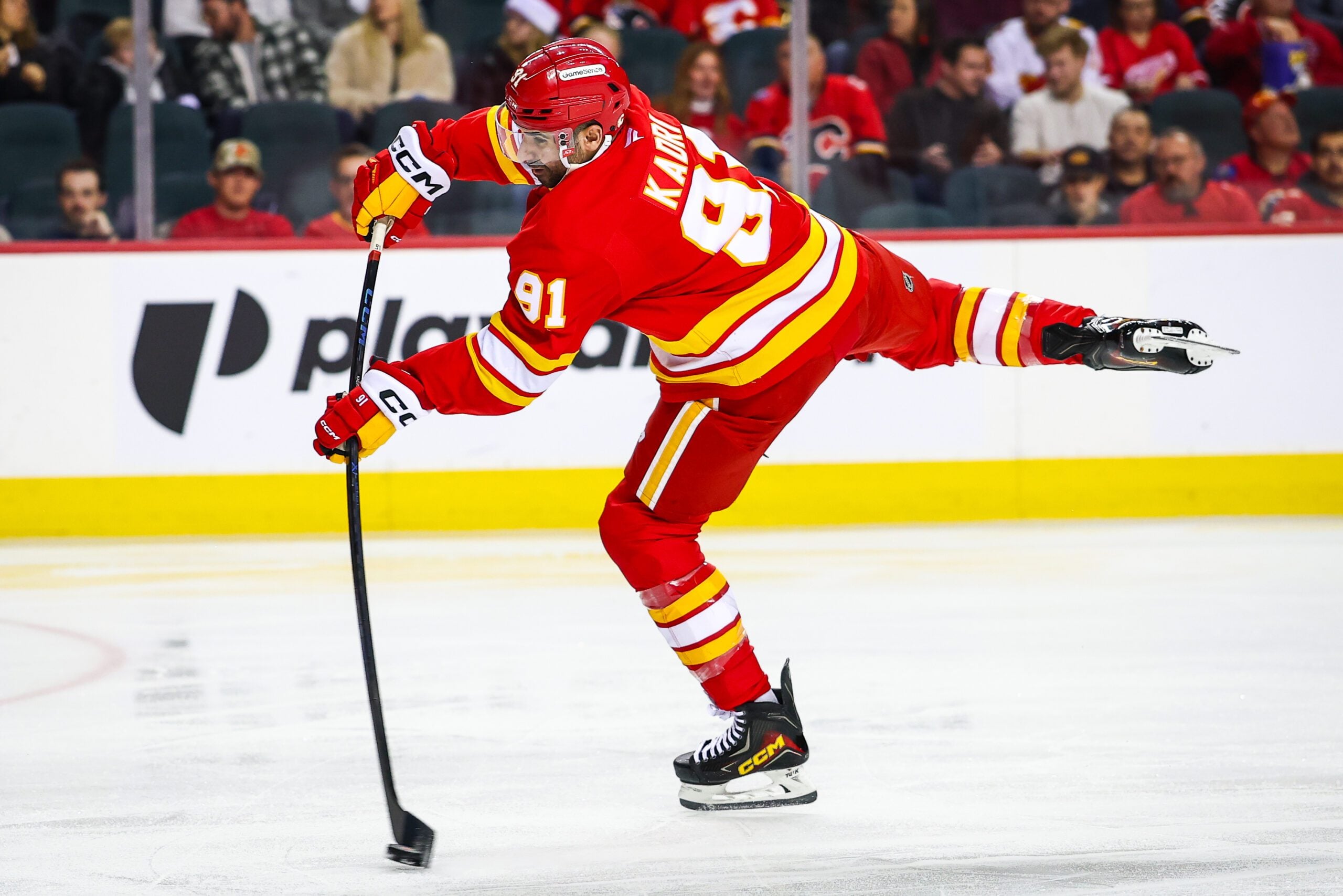 Dec 10, 2025; Calgary, Alberta, CAN; Calgary Flames center Nazem Kadri (91) shoots the puck against the Detroit Red Wings during the second period at Scotiabank Saddledome. Mandatory Credit: Sergei Belski-Imagn Images