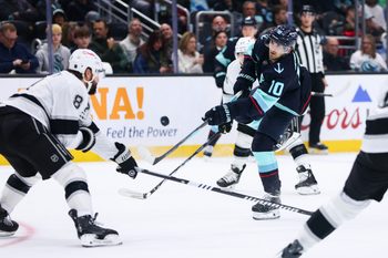 Dec 10, 2025; Seattle, Washington, USA; Seattle Kraken center Matty Beniers (10) attempts a shot on goal while defended by Los Angeles Kings defenseman Drew Doughty (8) in the first period at Climate Pledge Arena. Mandatory Credit: Kevin Ng-Imagn Images