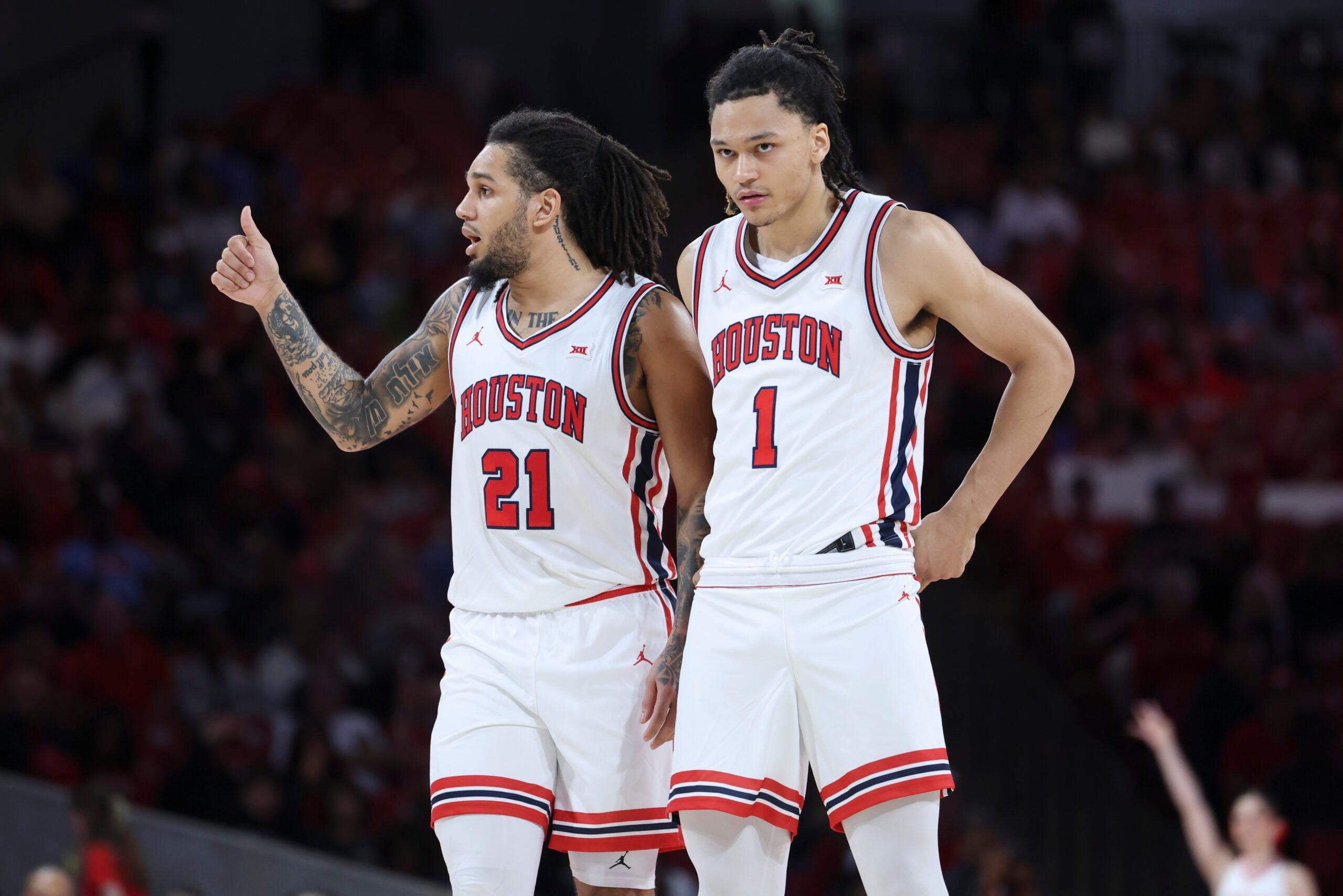 Dec 10, 2025; Houston, Texas, USA; Houston Cougars guard Isiah Harwell (1) looks on as guard Emanuel Sharp (21) gives a thumbs up during the second half against the Jackson State Tigers at Fertitta Center. Mandatory Credit: Troy Taormina-Imagn Images