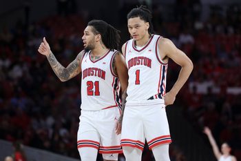 Dec 10, 2025; Houston, Texas, USA; Houston Cougars guard Isiah Harwell (1) looks on as guard Emanuel Sharp (21) gives a thumbs up during the second half against the Jackson State Tigers at Fertitta Center. Mandatory Credit: Troy Taormina-Imagn Images