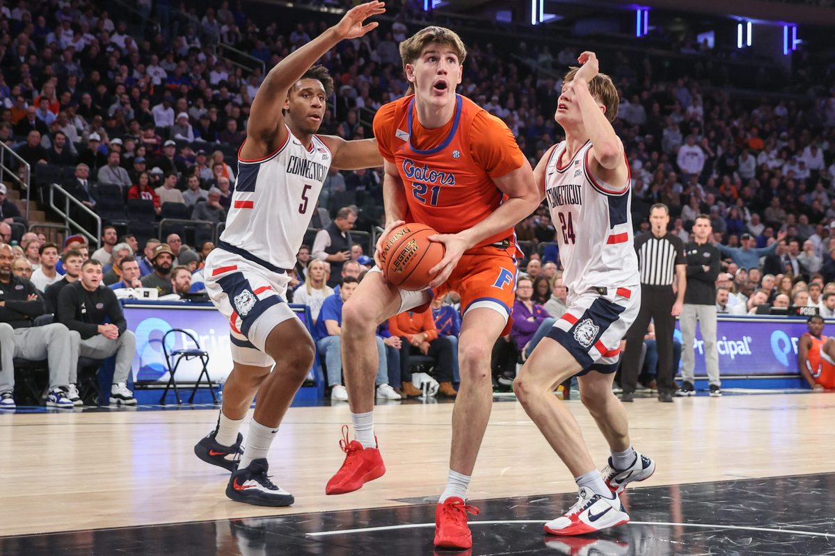 Dec 9, 2025; New York, New York, USA; Florida Gators forward Alex Condon (21) and UConn Huskies forward Tarris Reed Jr. (5) and guard Braylon Mullins (24) at Madison Square Garden. Mandatory Credit: Wendell Cruz-Imagn Images