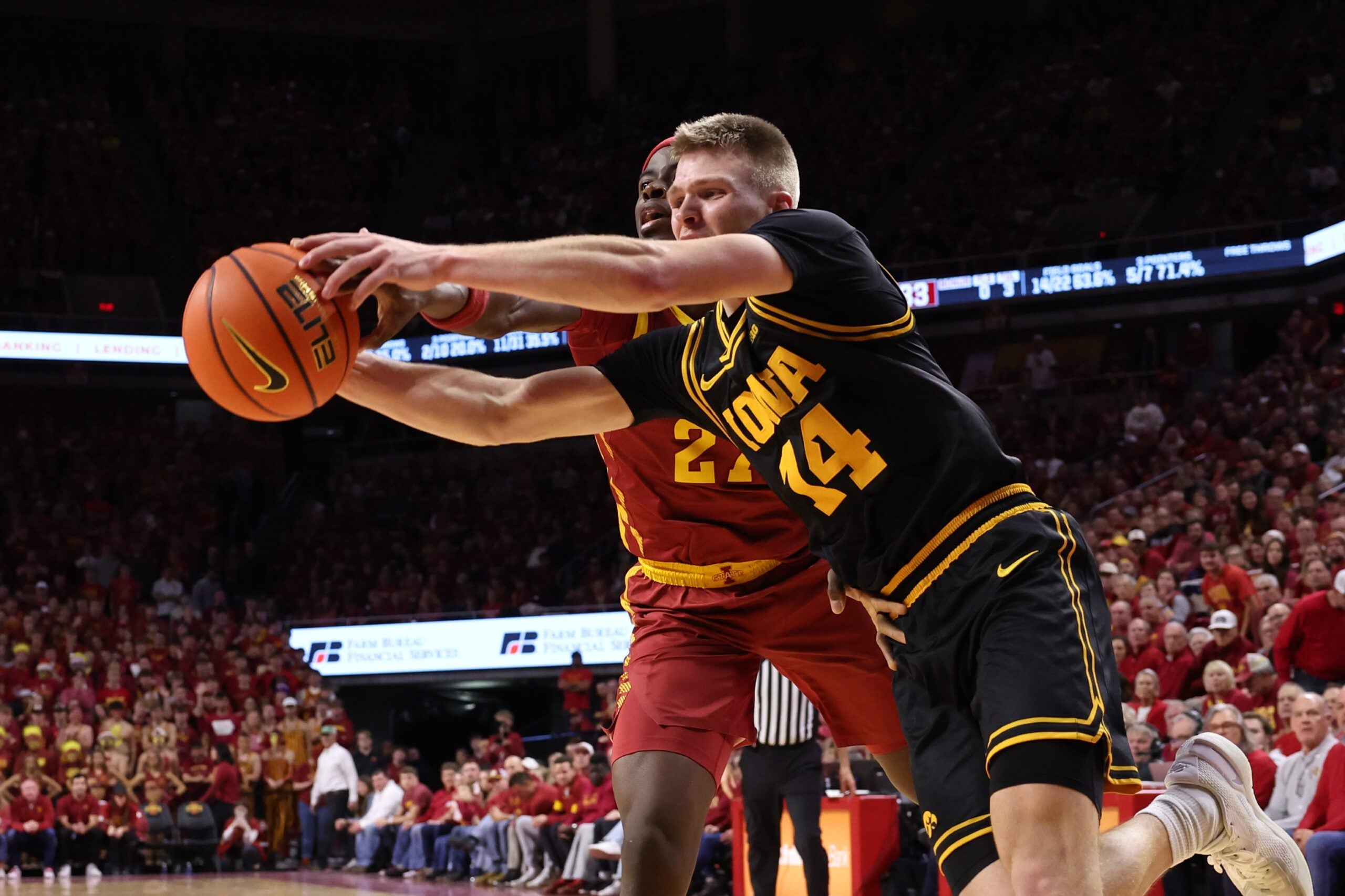 Dec 11, 2025; Ames, Iowa, USA; Iowa State Cyclones guard Killyan Toure (27) and Iowa Hawkeyes guard Bennett Stirtz (14) battle for a loose ball during the first half at James H. Hilton Coliseum. Mandatory Credit: Reese Strickland-Imagn Images