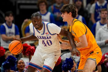 Dec 7, 2025; Kansas City, Missouri, USA; Kansas Jayhawks forward Flory Bidunga (40) dribbles the ball against Missouri Tigers forward Luke Northweather (45) during the second half at T-Mobile Center. Mandatory Credit: Jay Biggerstaff-Imagn Images