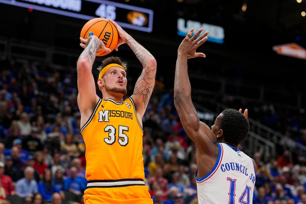 Dec 7, 2025; Kansas City, Missouri, USA; Missouri Tigers guard Jacob Crews (35) shoots against Kansas Jayhawks guard Melvin Council Jr. (14) during the second half at T-Mobile Center. Mandatory Credit: Jay Biggerstaff-Imagn Images