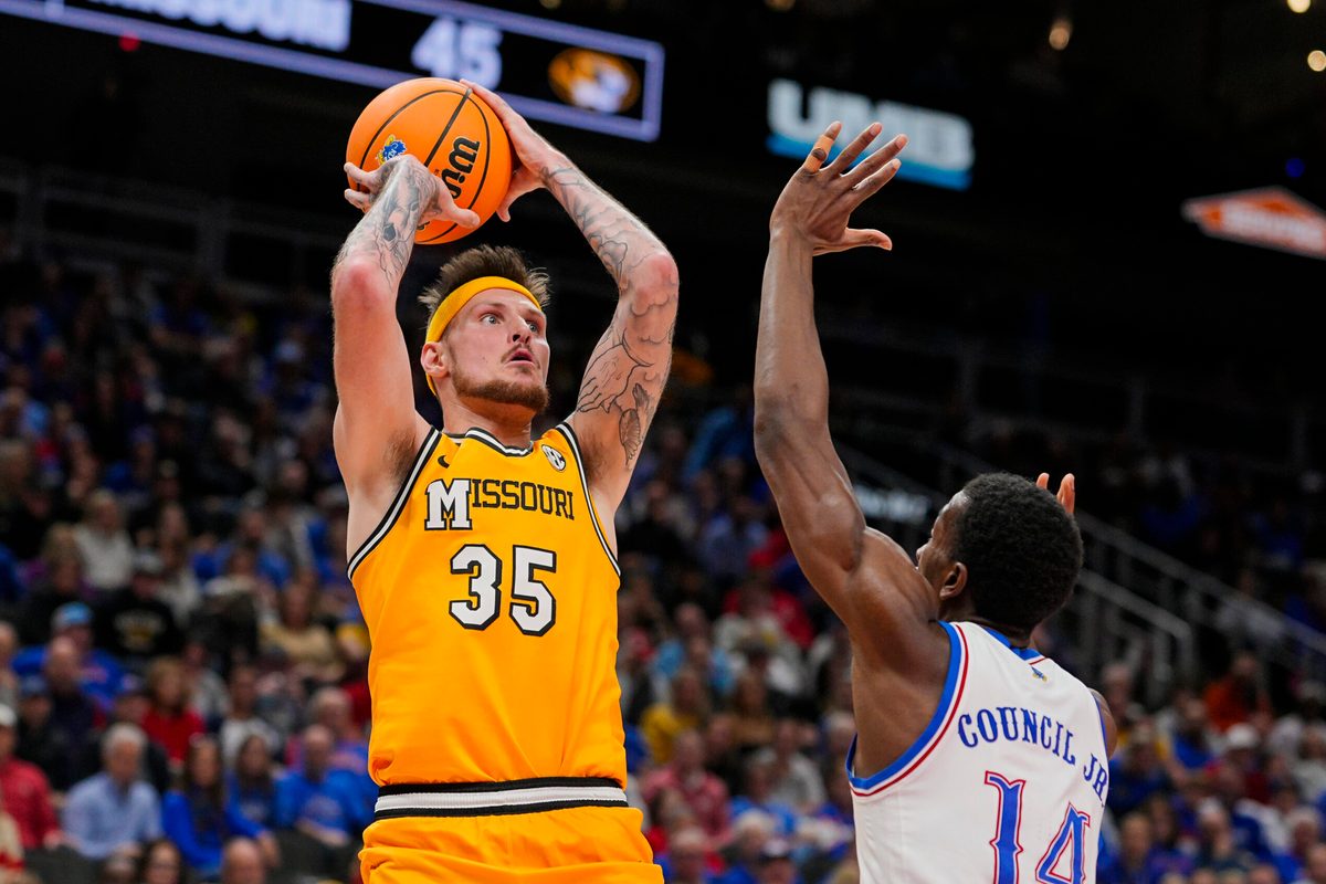 Dec 7, 2025; Kansas City, Missouri, USA; Missouri Tigers guard Jacob Crews (35) shoots against Kansas Jayhawks guard Melvin Council Jr. (14) during the second half at T-Mobile Center. Mandatory Credit: Jay Biggerstaff-Imagn Images
