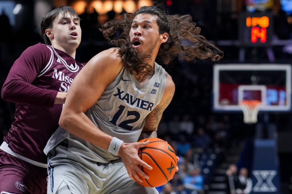 Dec 12, 2025; Cincinnati, Ohio, USA; Xavier Musketeers forward Tre Carroll (12) dribbles the ball against Missouri State Bears guard Logan Epes (6) in the first half at the Cintas Center. Mandatory Credit: Aaron Doster-Imagn Images
