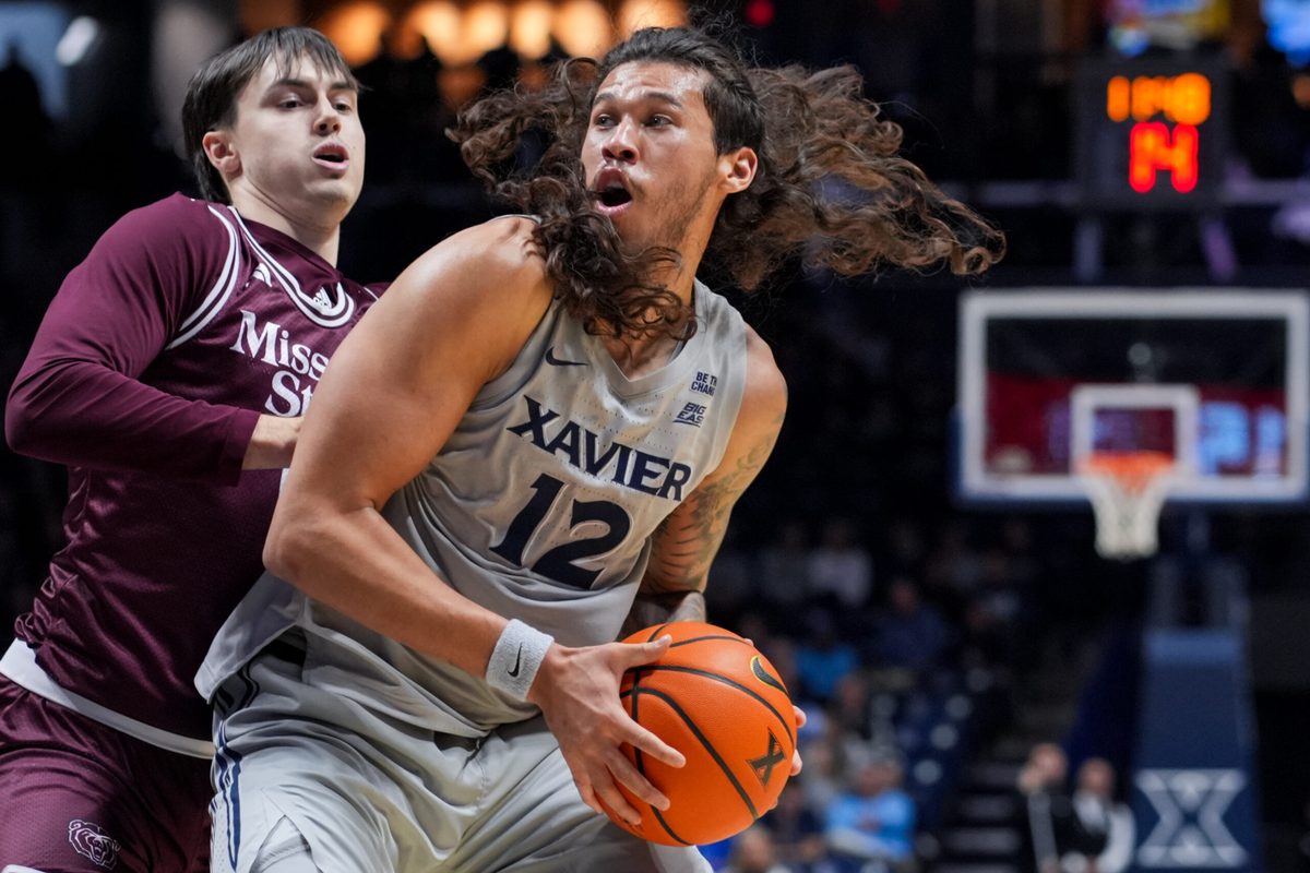 Dec 12, 2025; Cincinnati, Ohio, USA; Xavier Musketeers forward Tre Carroll (12) dribbles the ball against Missouri State Bears guard Logan Epes (6) in the first half at the Cintas Center. Mandatory Credit: Aaron Doster-Imagn Images