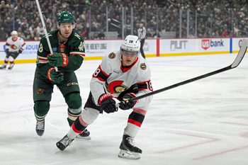 Dec 13, 2025; Saint Paul, Minnesota, USA;  .Minnesota Wild defensemen Daemon Hunt (48) and Ottawa Senators forward Tim Stutzle (18) chase after a loose puck during the first period at Grand Casino Arena. Mandatory Credit: Nick Wosika-Imagn Images