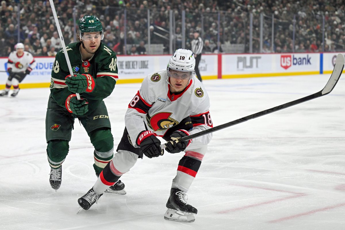 Dec 13, 2025; Saint Paul, Minnesota, USA; .Minnesota Wild defensemen Daemon Hunt (48) and Ottawa Senators forward Tim Stutzle (18) chase after a loose puck during the first period at Grand Casino Arena. Mandatory Credit: Nick Wosika-Imagn Images