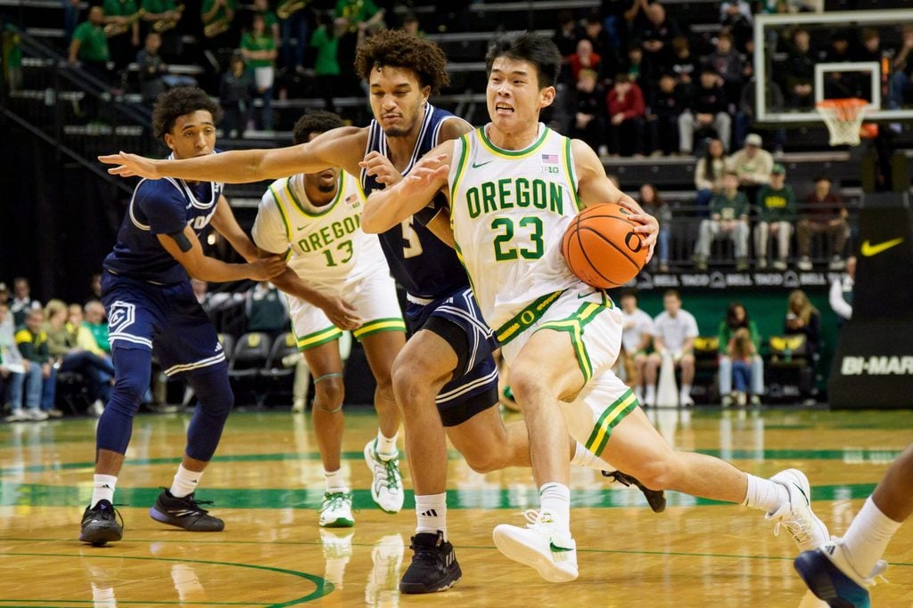 Oregon guard Wei Lin presses past UC Davis guard Jalen Stokes as the Oregon Ducks host the UC Davis Aggies on Dec. 13, 2025, at Matthew Knight Arena in Eugene, Oregon.