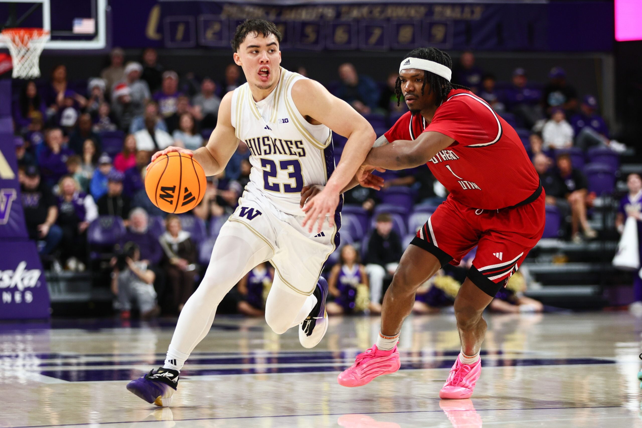 Dec 13, 2025; Seattle, Washington, USA; Washington Huskies guard JJ Mandaquit (23) drives the ball while defended by Southern Utah Thunderbirds guard Elijah Duval (1) in the second half at Alaska Airlines Arena at Hec Edmundson Pavilion. Mandatory Credit: Kevin Ng-Imagn Images
