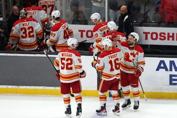 Dec 13, 2025; Los Angeles, California, USA;  Calgary Flames center Morgan Frost (16) celebrates with defenseman Mackenzie Weegar (52) and defenseman Rasmus Andersson (right) after defeating the Los Angeles Kings in overtime at Crypto.com Arena. Mandatory Credit: Kiyoshi Mio-Imagn Images
