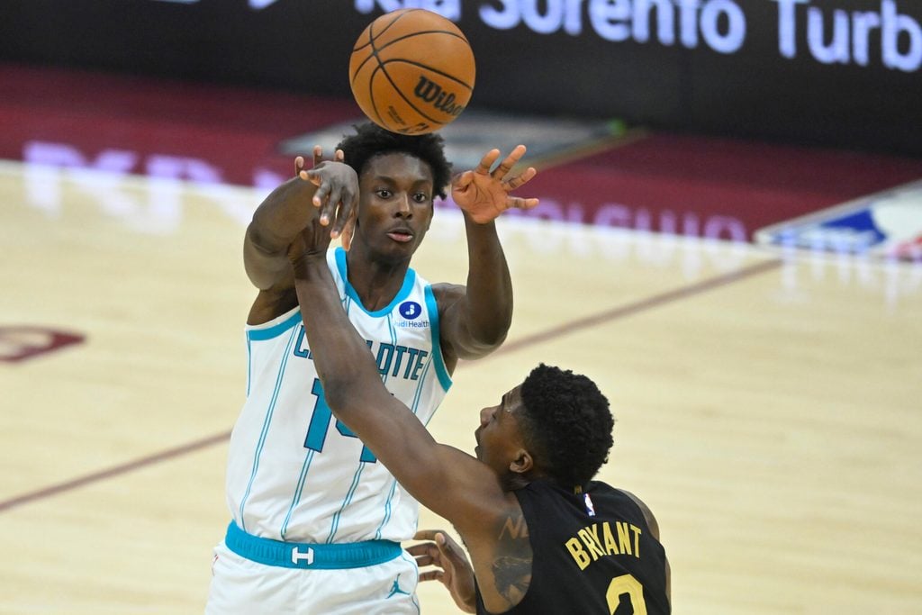 Dec 14, 2025; Cleveland, Ohio, USA; Charlotte Hornets forward Moussa Diabate (14) passes the ball beside Cleveland Cavaliers center Thomas Bryant (3) in the third quarter at Rocket Arena. Mandatory Credit: David Richard-Imagn Images