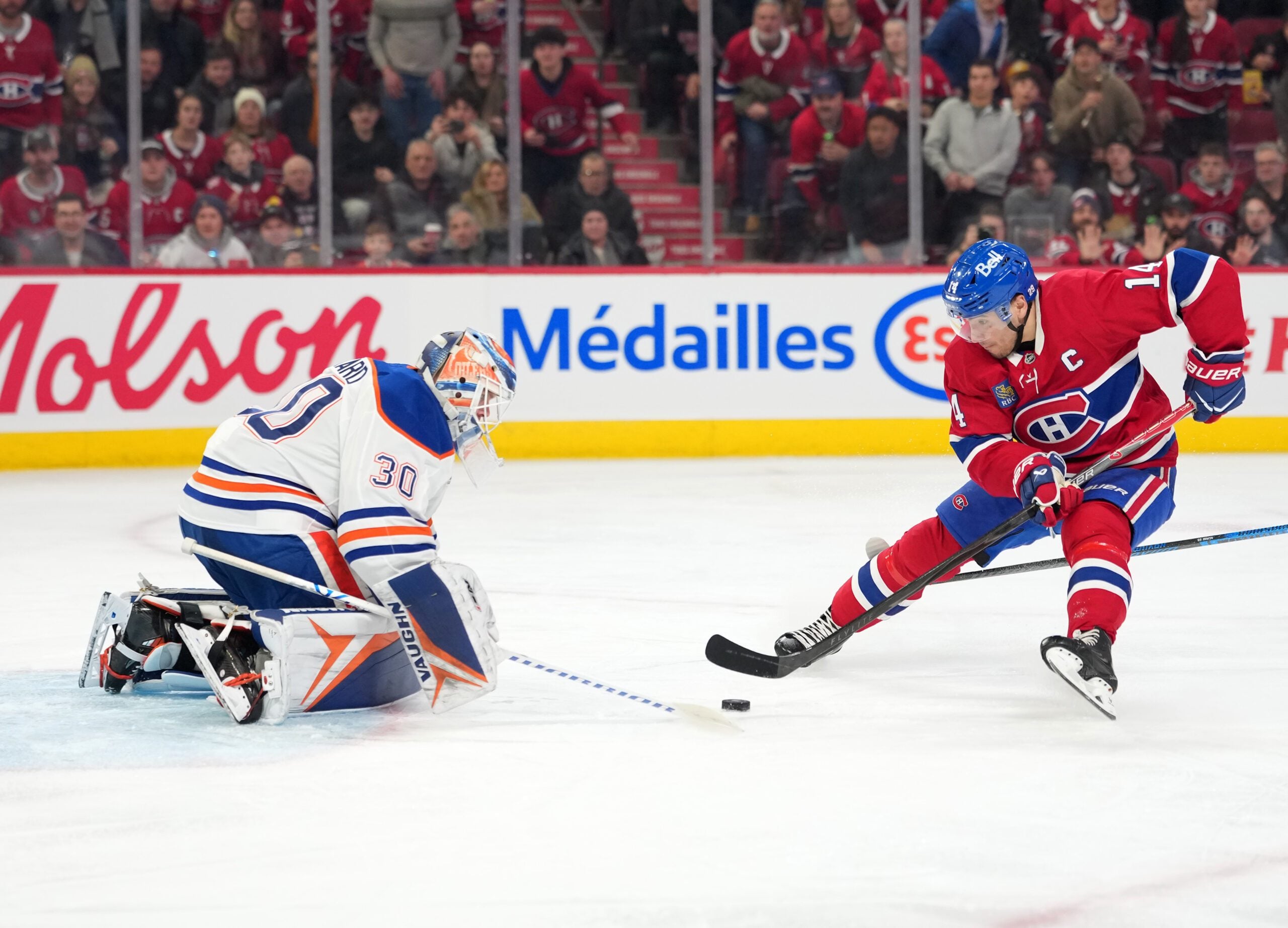 Dec 14, 2025; Montreal, Quebec, CAN; Edmonton Oilers goalie Calvin Pickard (30) gets the puck away from Montreal Canadiens forward Nick Suzuki (14) during the second period at the Bell Centre. Mandatory Credit: Eric Bolte-Imagn Images