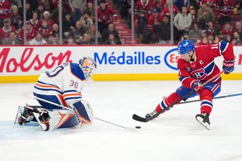 Dec 14, 2025; Montreal, Quebec, CAN; Edmonton Oilers goalie Calvin Pickard (30) gets the puck away from Montreal Canadiens forward Nick Suzuki (14) during the second period at the Bell Centre. Mandatory Credit: Eric Bolte-Imagn Images