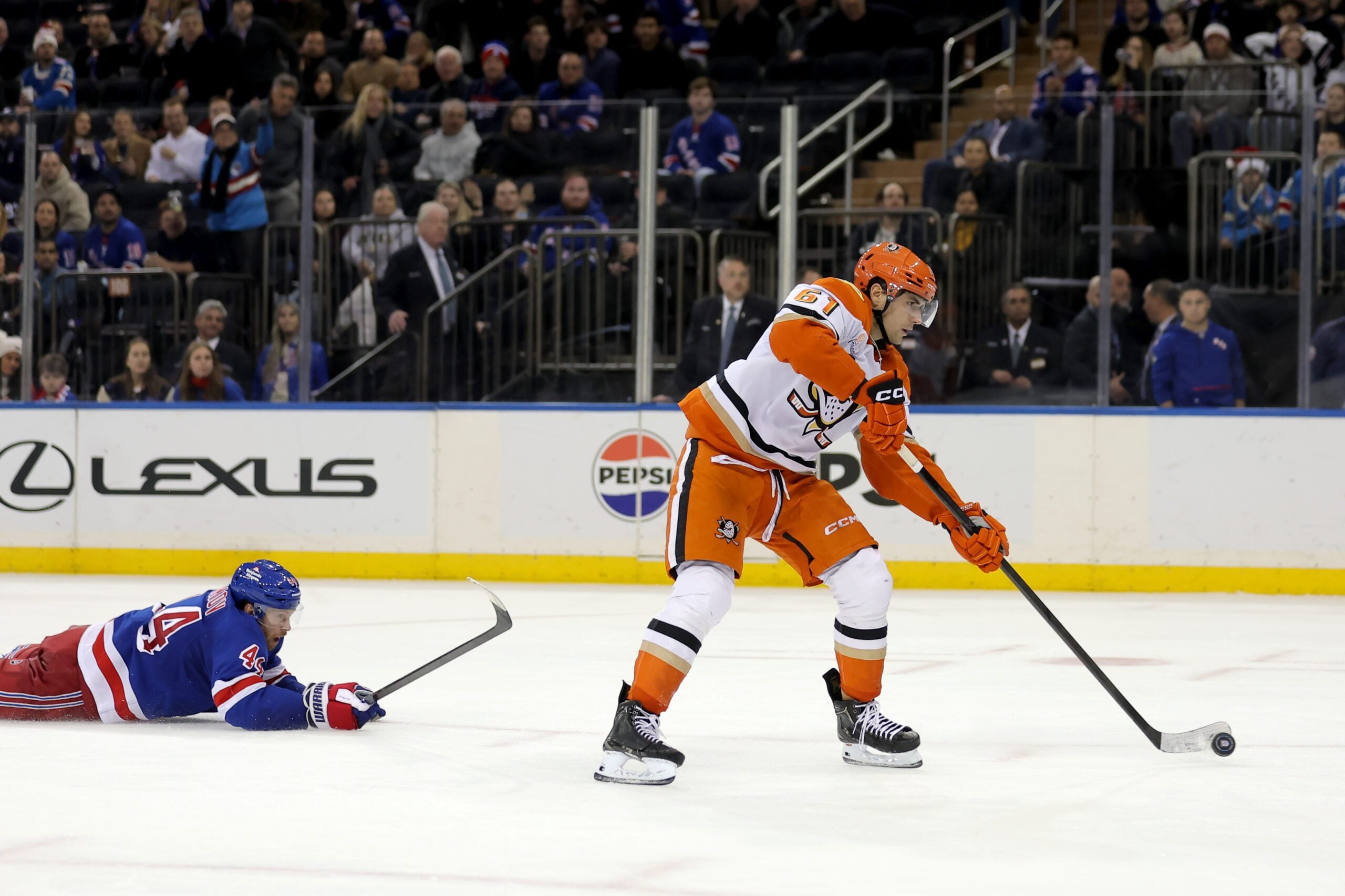 Dec 15, 2025; New York, New York, USA; Anaheim Ducks left wing Cutter Gauthier (61) scores an empty net goal against New York Rangers defenseman Vladislav Gavrikov (44) during the third period at Madison Square Garden. Mandatory Credit: Brad Penner-Imagn Images