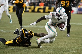 Dec 15, 2025; Pittsburgh, Pennsylvania, USA; Miami Dolphins running back De'Von Achane (28) escapes a tackle by Pittsburgh Steelers cornerback Brandin Echols (26) in the fourth quarter at Acrisure Stadium. Mandatory Credit: Barry Reeger-Imagn Images