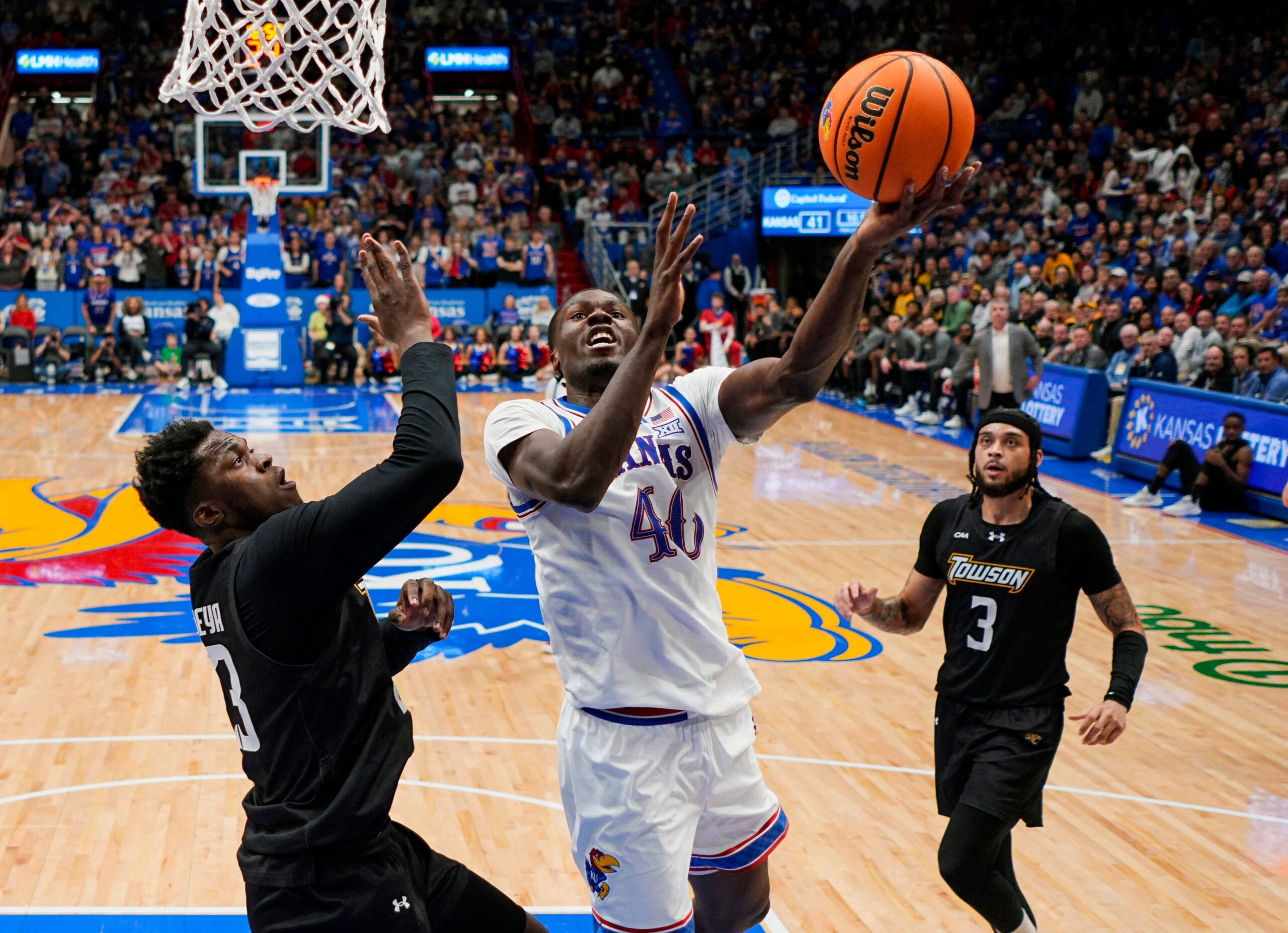 Dec 16, 2025; Lawrence, Kansas, USA; Kansas Jayhawks forward Flory Bidunga (40) shoots against Towson Tigers forward Caleb Embeya (23) during the second half at Allen Fieldhouse. Mandatory Credit: Jay Biggerstaff-Imagn Images