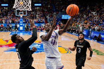 Dec 16, 2025; Lawrence, Kansas, USA; Kansas Jayhawks forward Flory Bidunga (40) shoots against Towson Tigers forward Caleb Embeya (23) during the second half at Allen Fieldhouse. Mandatory Credit: Jay Biggerstaff-Imagn Images