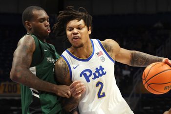 Dec 17, 2025; Pittsburgh, Pennsylvania, USA;  Pittsburgh Panthers forward Cameron Corhen (2) dribbles the ball against pressure from Binghamton Bearcats center Demetrius Lilley (left) during the second half at the Petersen Events Center. Mandatory Credit: Charles LeClaire-Imagn Images