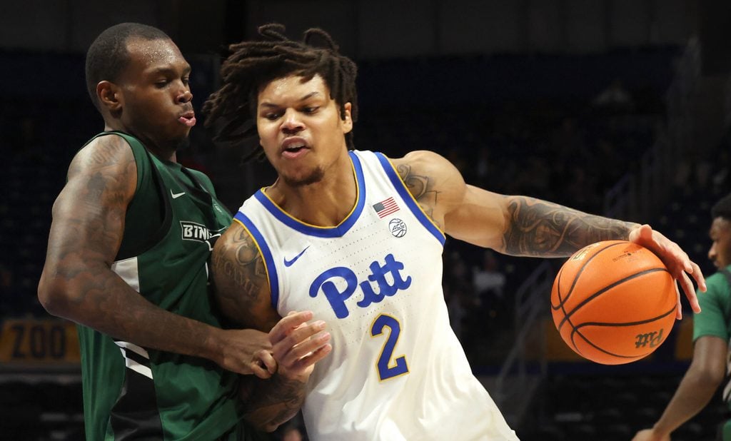 Dec 17, 2025; Pittsburgh, Pennsylvania, USA; Pittsburgh Panthers forward Cameron Corhen (2) dribbles the ball against pressure from Binghamton Bearcats center Demetrius Lilley (left) during the second half at the Petersen Events Center. Mandatory Credit: Charles LeClaire-Imagn Images